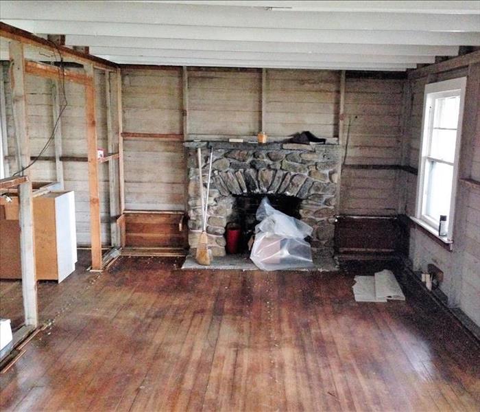 living room with damaged walls and floor