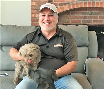 Man with dog sitting on couch