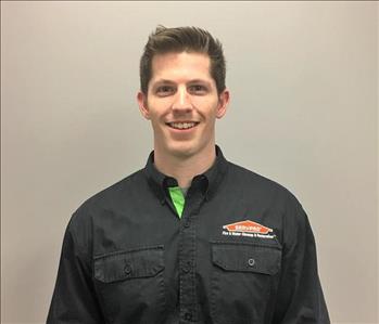 Man with brown hair and black servpro shirt 