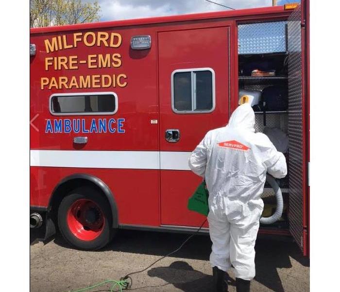 man with a SERVPRO suit cleaning a firetruck